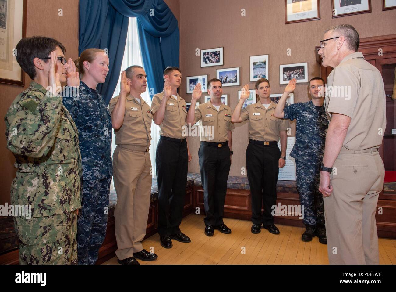 WASHINGTON (16. Mai 2018) Captain Ken Collins, kommandierender Offizier der US-Marine Band, Recht, leitet eine erneute Eintragung Zeremonie für, von Links nach Rechts, Musiker 1. Klasse Allison Fletcher und Lauren Geist, Senior Chief Musiker Luis Hernandez, und Musiker 1. Klasse Peter Pirotte, Travis Siehndel, Tyler Worosello und Jonathan Yanik in der Sail Loft auf der historischen Washington Navy Yard. Stockfoto