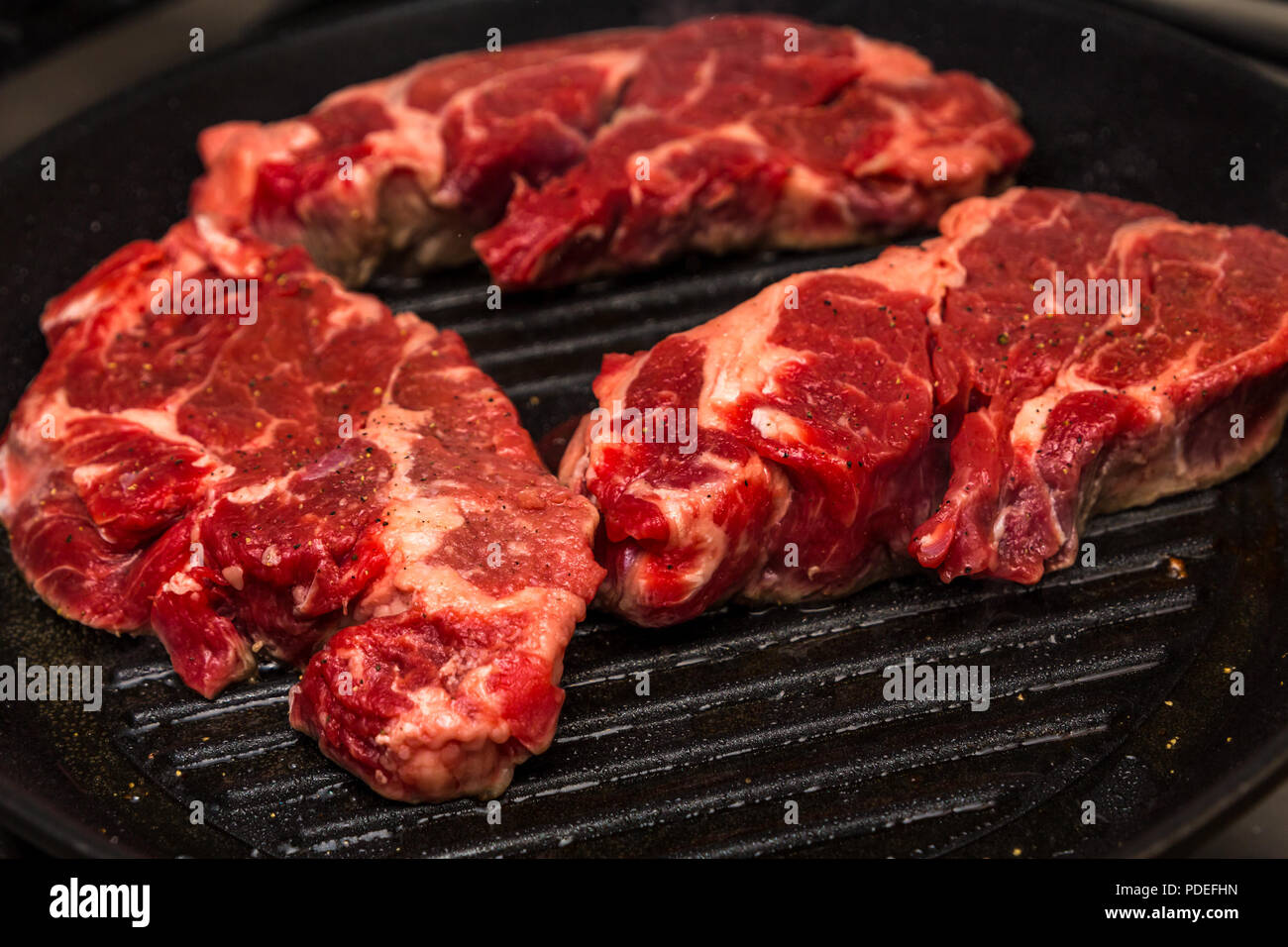 Drei Chuck Steaks auf Skillet Stockfoto