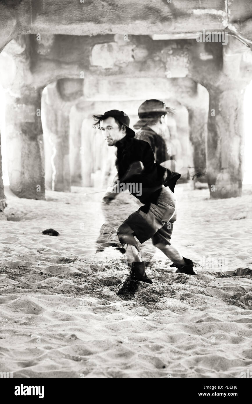 Fine Art schwarz-weiß Foto von einem Tänzer in den Sand unter der Pier. Auch als lizenzfreie Fotos. Premium Bild. Stockfoto