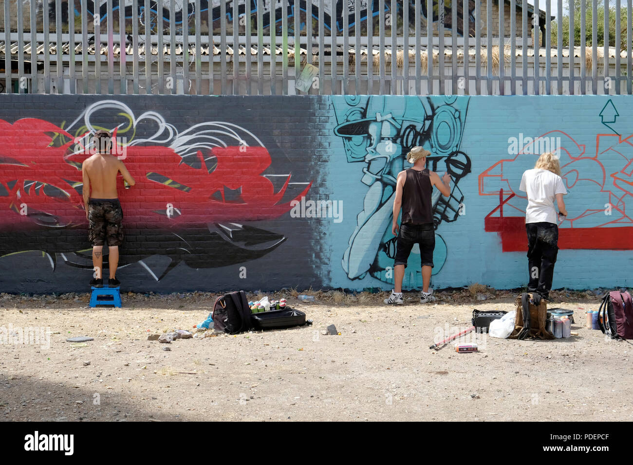 Drei Graffiti Künstler arbeiten an einem Wandbild in Brick Lane, London Stockfoto