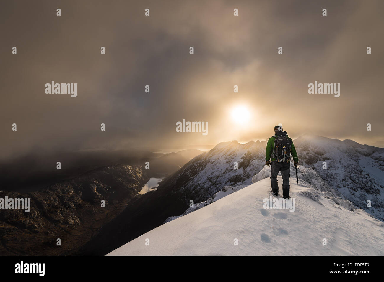 Bergsteiger auf schneebedeckten Bergrücken mit Sonnenaufgang über dem Cuillin Ridge in Isle of Skye, Abbildung im Querformat Stockfoto