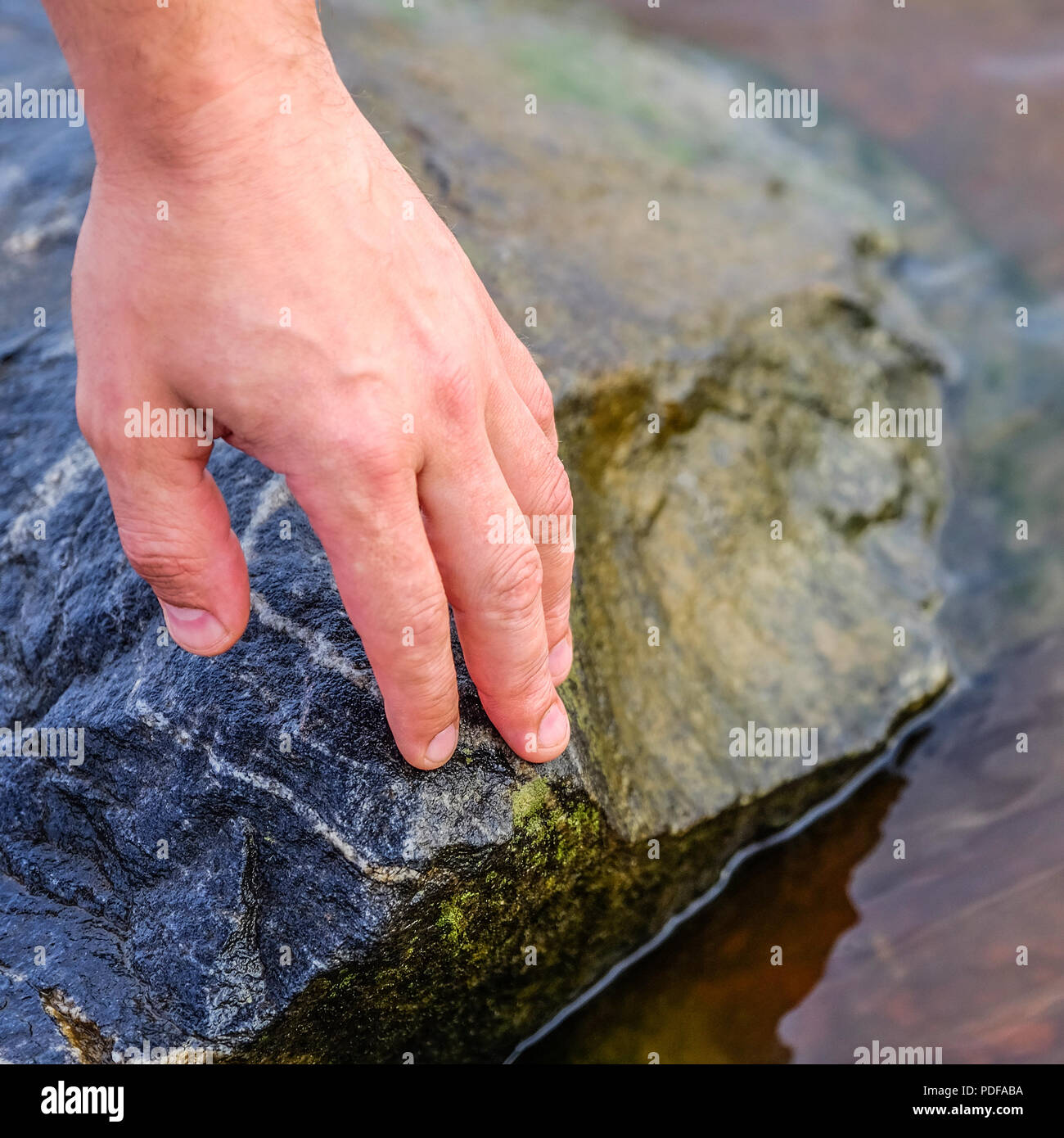 Hand Stein auf Stapeln Steine am Ufer. Die Steine sind auf dem Ufer gestapelt. Auf dem Hintergrund der Wasser Stockfoto