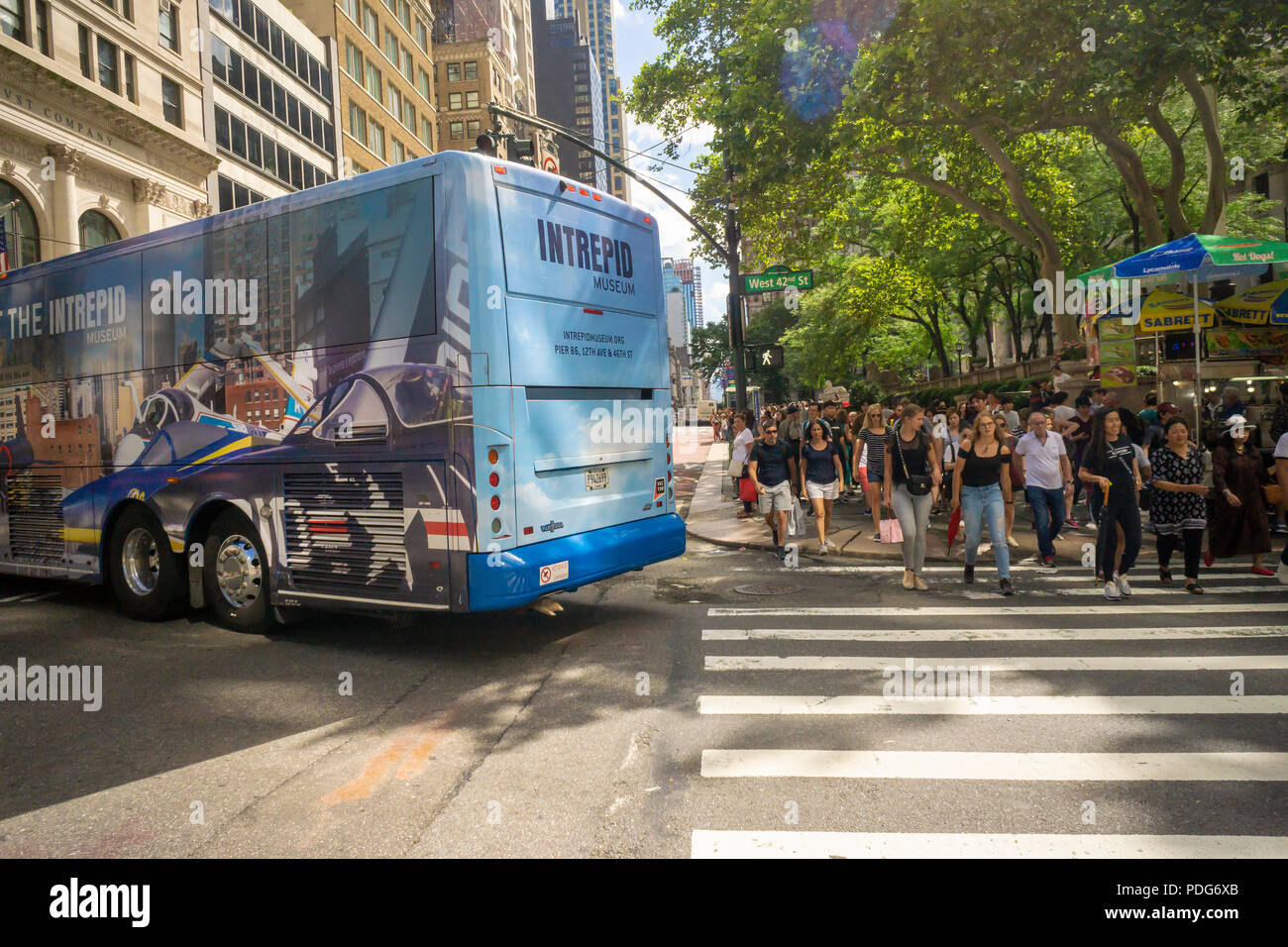 Fußgänger kreuz West 42nd Street als Bus auf der Fifth Avenue in Midtown Manhattan in New York am Samstag, 4. August 2018 dreht. (© Richard B. Levine) Stockfoto
