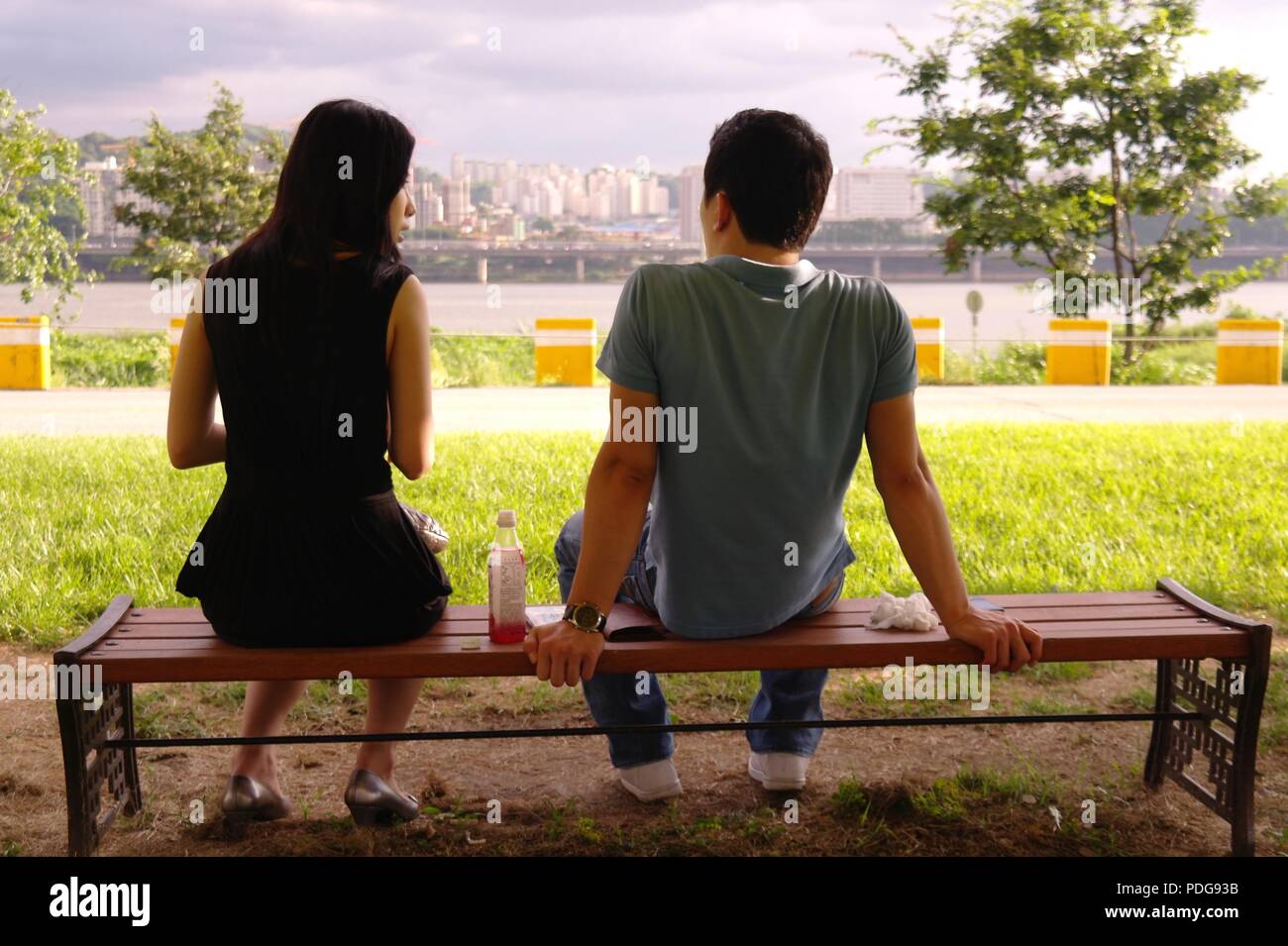 Asiatische Paar sitzt auf der Bank durch den Fluss Han, Hangang. In Gespräch und dating in Seoul, Südkorea. Stockfoto