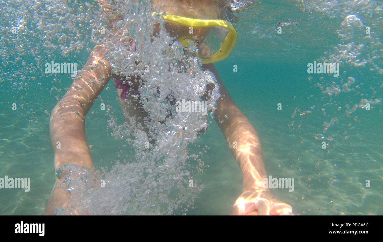 Portrait von kleinen Mädchen Schwimmen unter Wasser im Meer. Süße Mädchen in Maske schafft Blasen unter Wasser. Sommer Urlaub. Kleine Mädchen hat Spaß. Platz kopieren Stockfoto