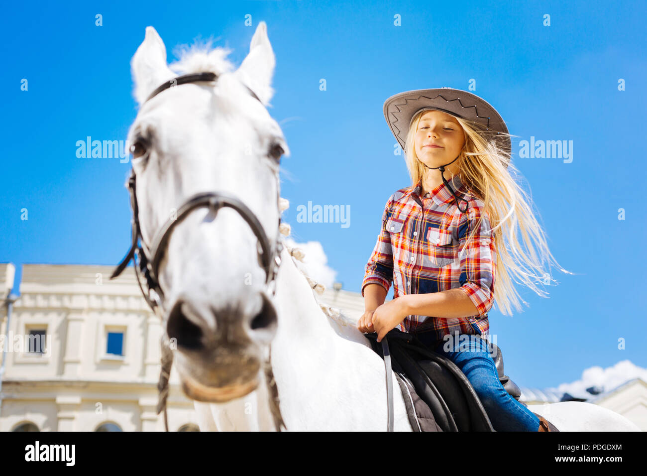 Mädchen mit langen blonden Haaren Gefühl schön beim Reiten Pferd Stockfoto