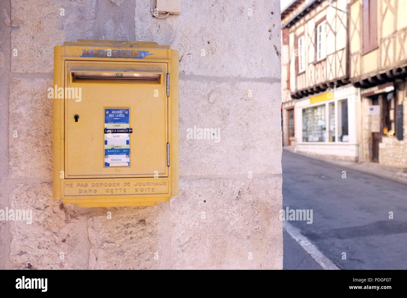Gelbe Briefkasten in der kleinen Marktstadt Issigeac in Südwest Frankreich August 2018. Stockfoto
