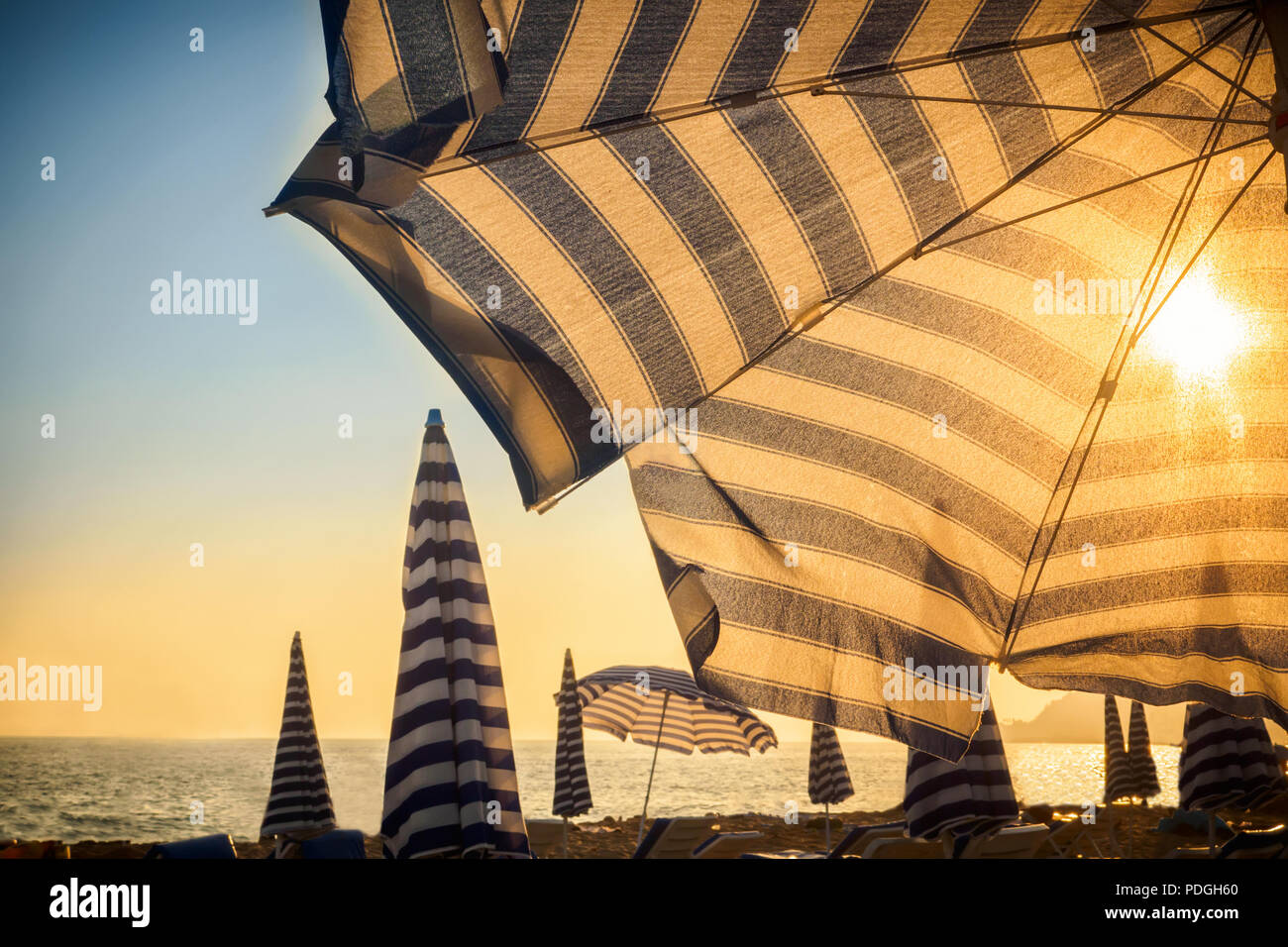 Sonnenschirm und Sonne vor bei Sonnenuntergang auf sandigen Strand der Stadt am Meer Ozean Konzept der Tourismus reisen und Körper Haut Schutz von Melanom der Haut cance Stockfoto