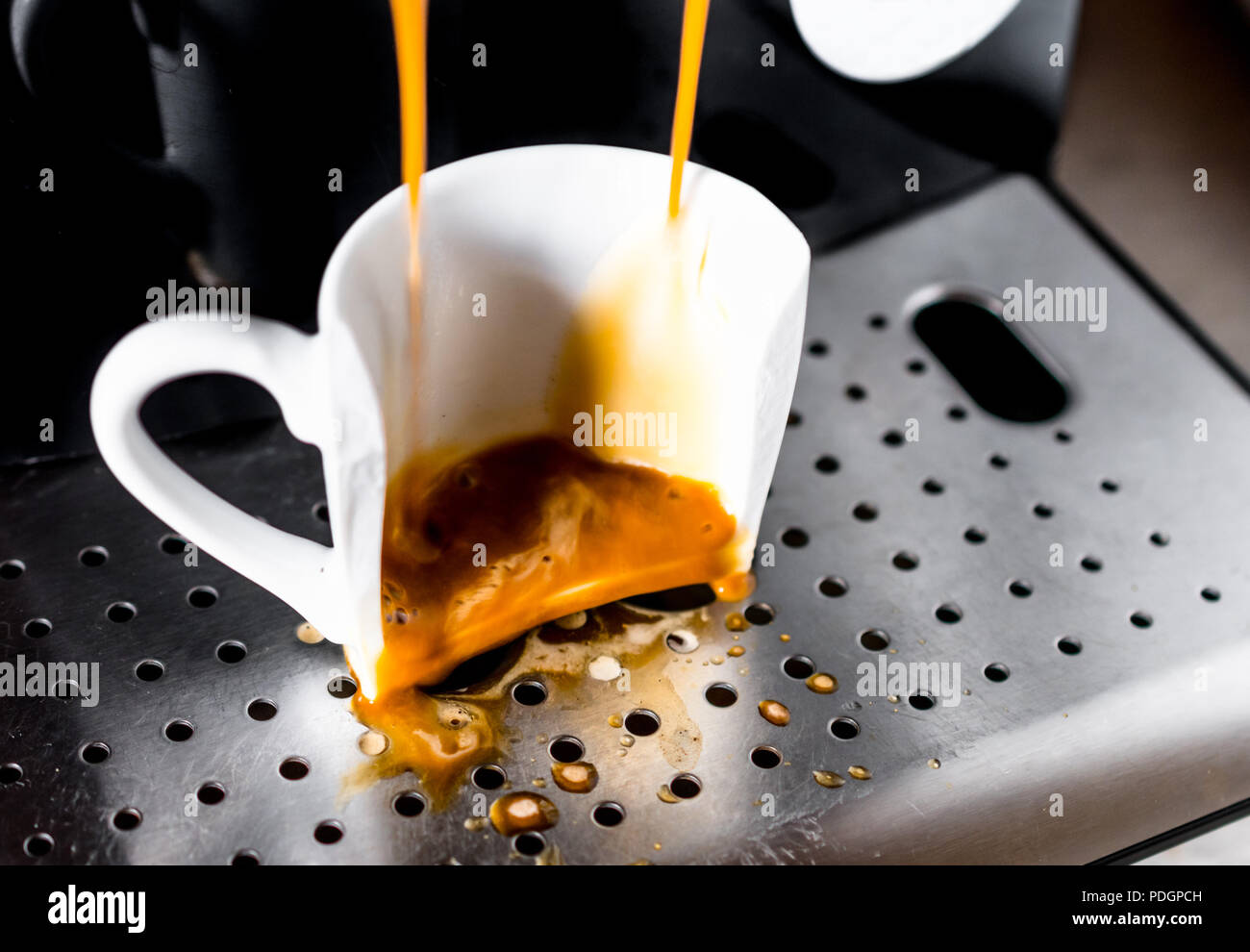 Kaffee verschüttet in gebrochen Cup auf einem Home Espresso Maschine. Konzept der schlechten Morgen Stockfoto