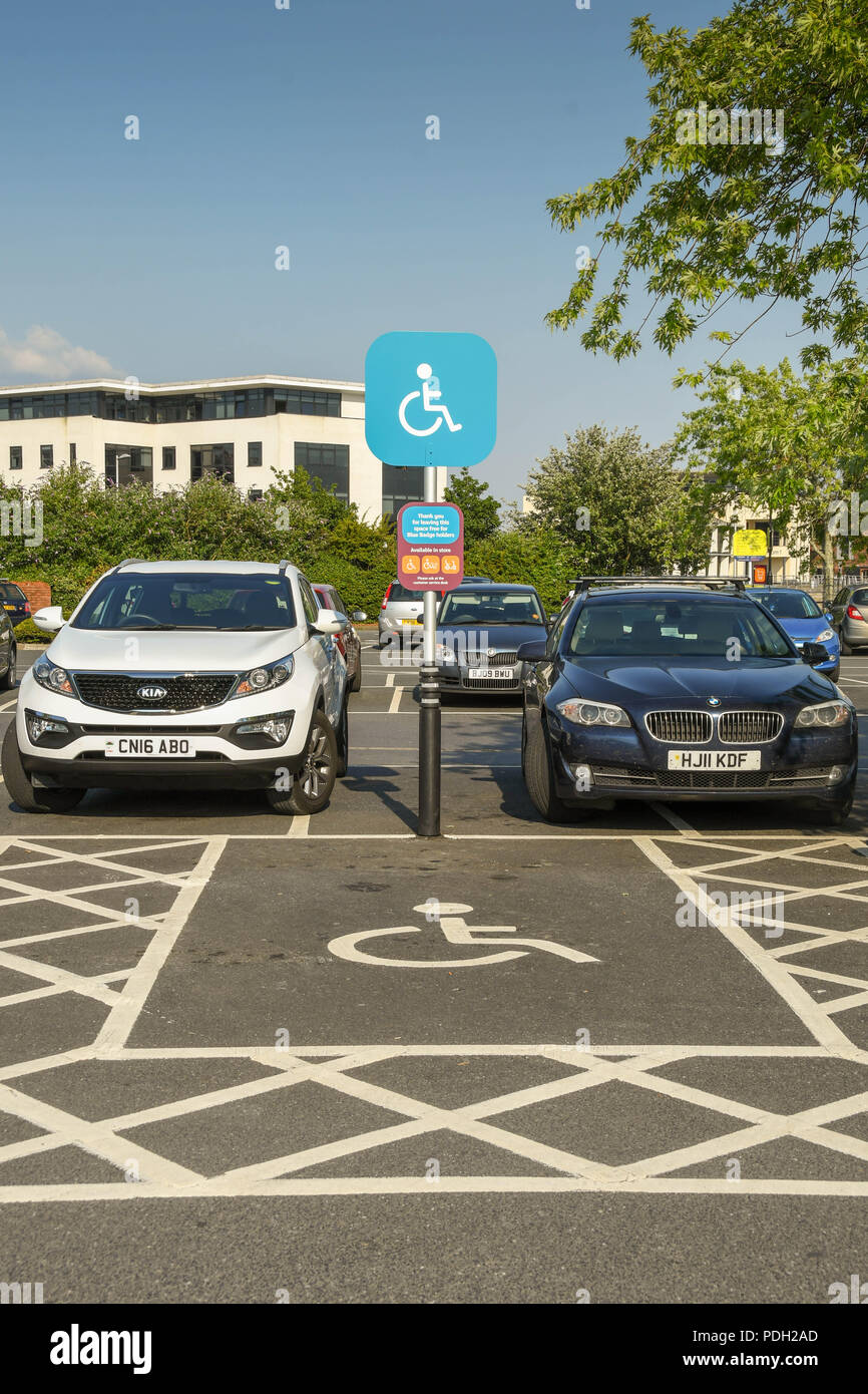 Wegweiser und Markierungen auf dem Boden und einen Parkplatz für Behinderte reserviert kennzeichnen Stockfoto