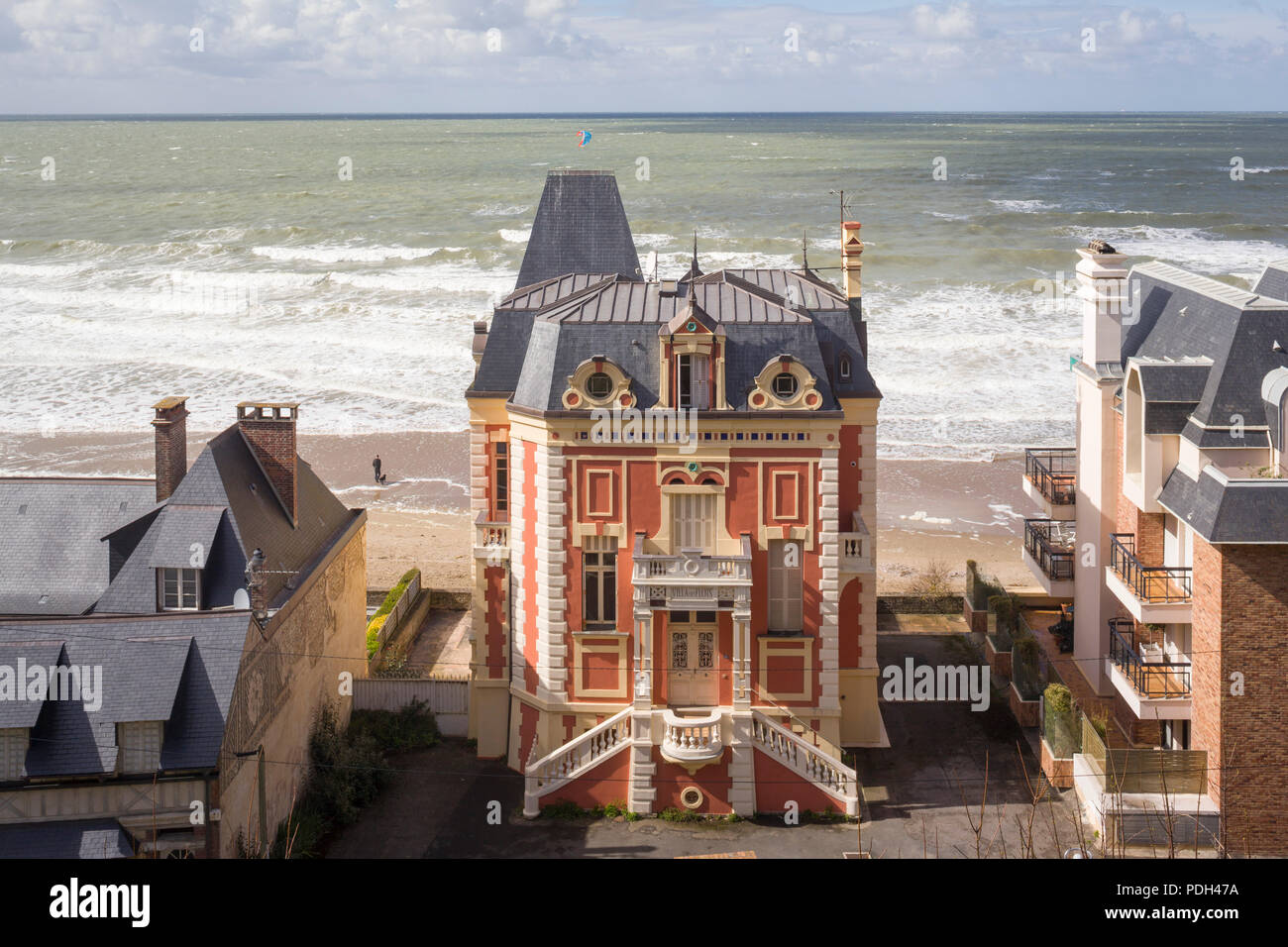 Die 'Villa des Flots', einem Belle Epoque Haus am Strand von Trouville-sur-Mer, Normandie, Frankreich mit der rauen See hinter Stockfoto