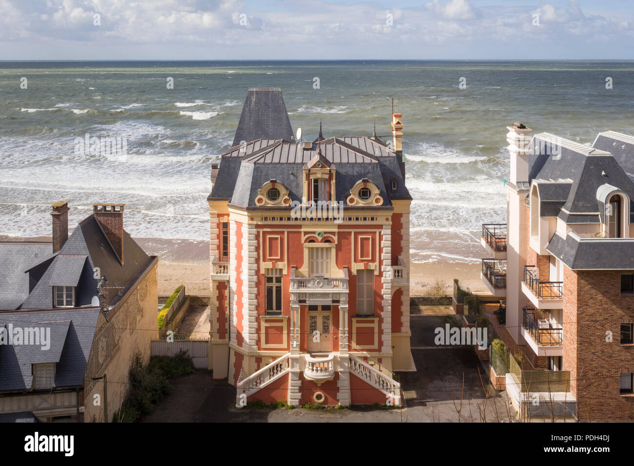 Die 'Villa des Flots', einem Belle Epoque Haus am Strand von Trouville-sur-Mer, Normandie, Frankreich mit der rauen See hinter Stockfoto