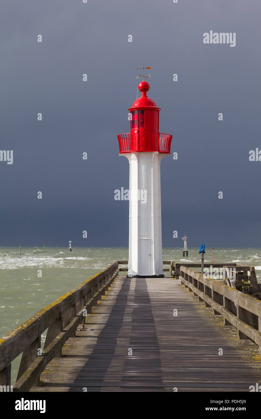 Die rot lackierten Osten Leuchtturm Schutz der Hafen in Trouville-sur-Mer, Normandie, Frankreich mit einem Sturm in hinter Stockfoto