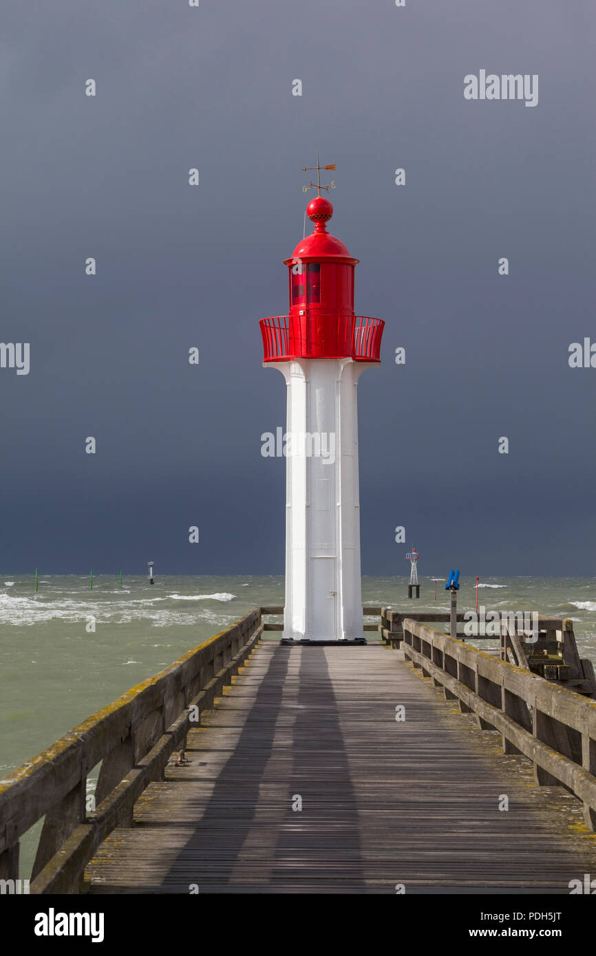 Die rot lackierten Osten Leuchtturm Schutz der Hafen in Trouville-sur-Mer, Normandie, Frankreich mit einem Sturm in hinter Stockfoto