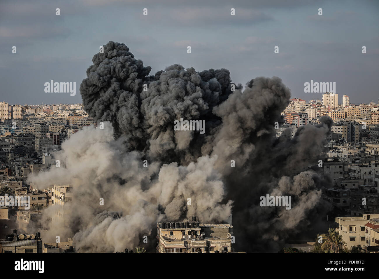 Gaza, Gazastreifen. 09 Aug, 2018. Rauch steigt aus einem mehrstöckigen Gebäude nach wurde es durch ein israelisches Flugzeug in Gaza, Gazastreifen, 09. August 2018 bombardiert. Nach Angaben der israelischen Armee, hat Israel eine Welle von Luftangriffen auf den Gazastreifen als Reaktion auf mehr als 180 Raketen und Mörsergranaten auf Israel abgefeuert wurde, und Geschützfeuer früheren Mittwoch, dass gezielte zivile Bauarbeiter auf der Grenze zum Gazastreifen eingeleitet. Credit: Emad Awad/dpa/Alamy leben Nachrichten Stockfoto
