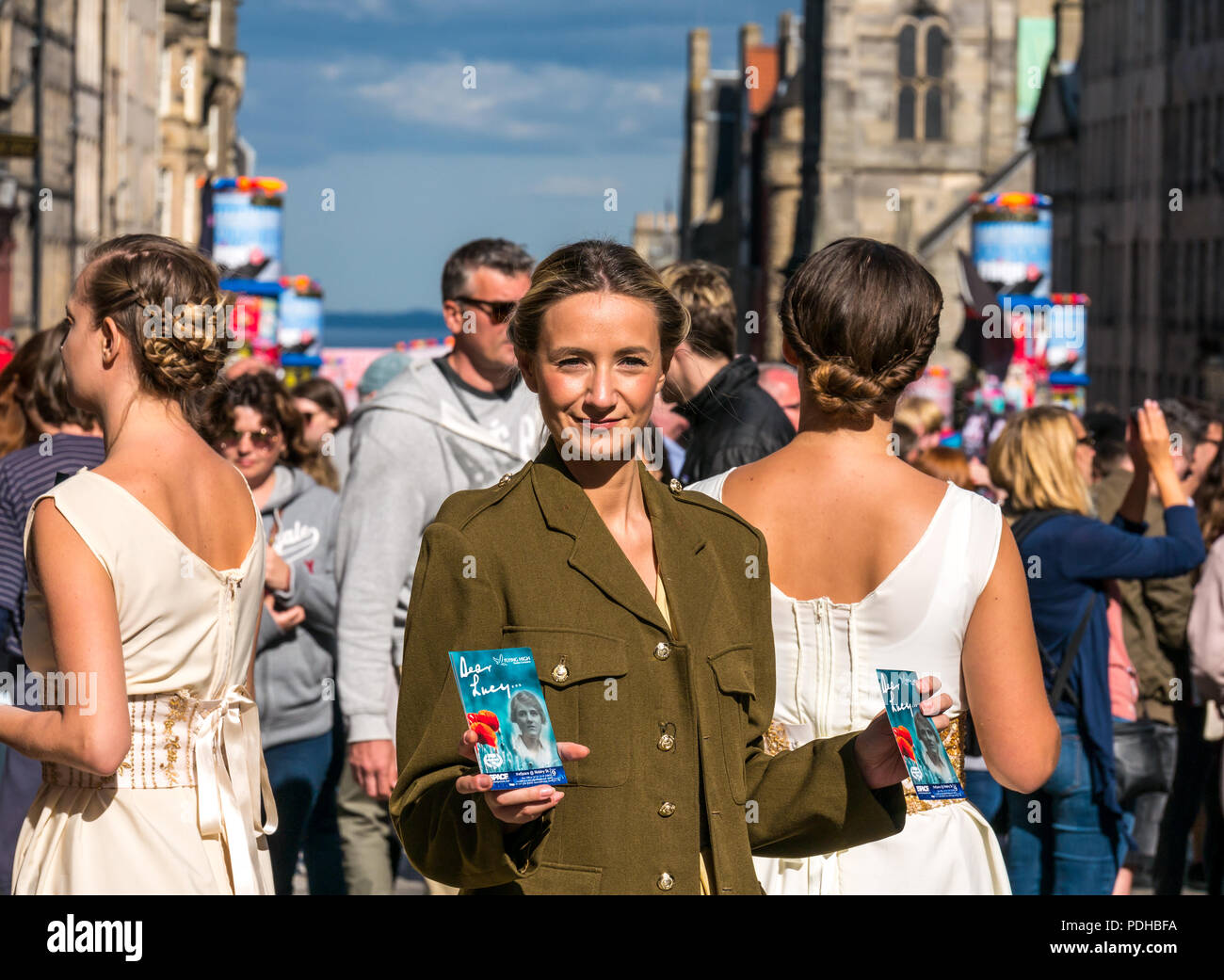 Edinburgh, Schottland, Großbritannien. 9. August 2018. Edinburgh Fringe Festival, Royal Mile, Edinburgh, Schottland, Vereinigtes Königreich. An einem sonnigen Festival Tag der Jungfrau Geld gesponsert Street Festival mit Menschen und fringe Darsteller verpackt ist. Eine Gruppe von hübschen jungen Frauen im Zweiten Weltkrieg Kostüme gekleidet hand Flyer für Ihre Fringe Show namens Liebe Lucy Stockfoto