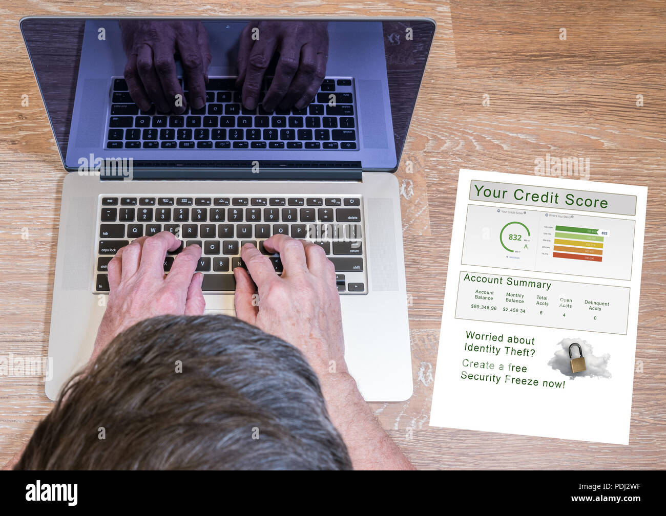 Man tippt auf Laptop mit Credit Report Stockfoto
