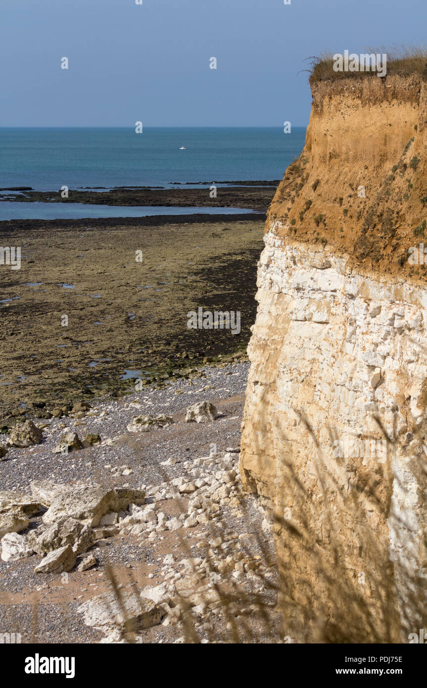 Bröckelnde Felsen in der Nähe von sieben Schwestern UK Hochformat Küste Bild mit kalkhaltigen Felsen Meer unten mit gefallenen Cliff Material blaues Meer übersät. Stockfoto