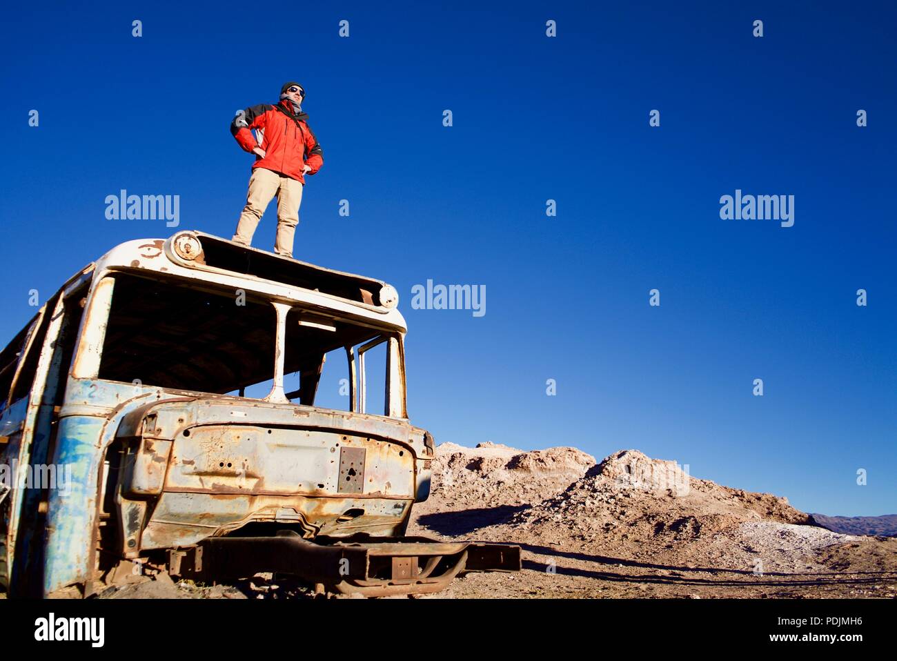Bereit, sich neuen Herausforderungen zu stellen. Auf einem verlassenen Bus in der Atacama Wüste sehr früh am Morgen getroffen Stockfoto