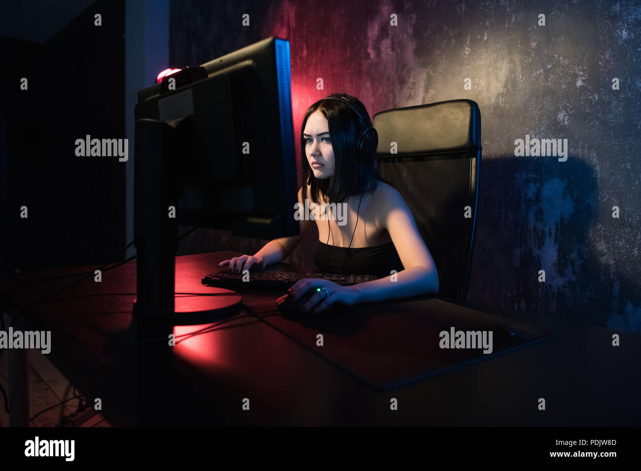 Junge attraktive Frau Videospiele auf Ihrem Computer Gaming Headset tragen. Stockfoto