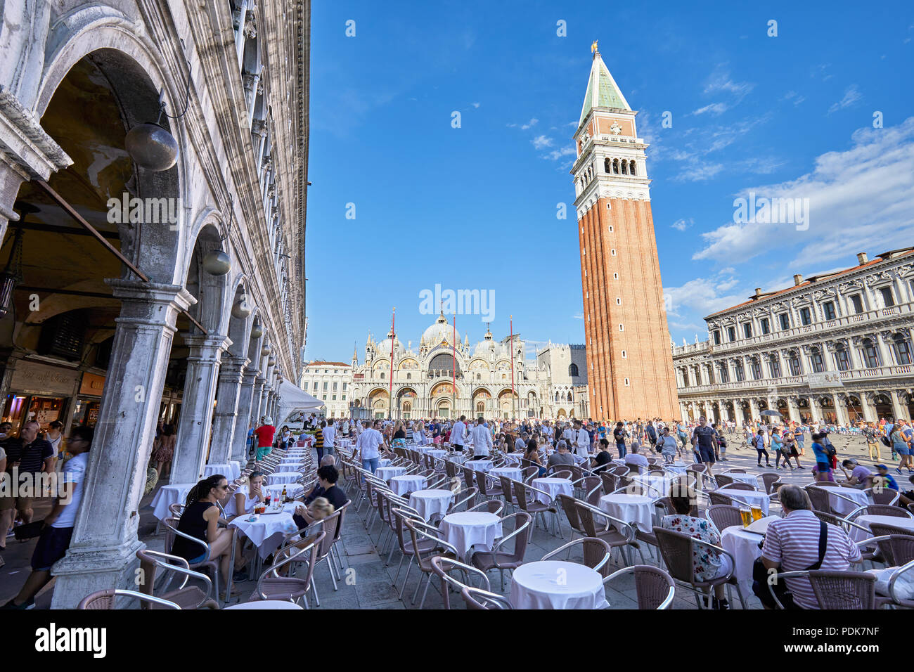Saint Mark Square mit Bürgersteig Tabelle mit Menschen und Touristen, blauer Himmel an einem sonnigen Sommertag in Italien Stockfoto