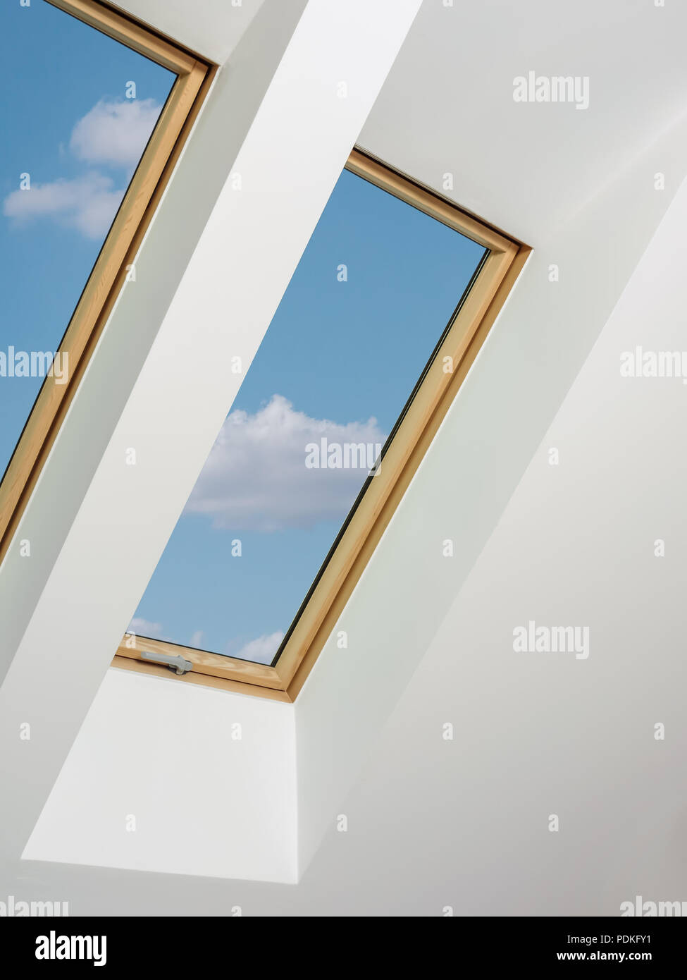 Zwei Dachboden Fenster mit blauem Himmel anzeigen Stockfoto