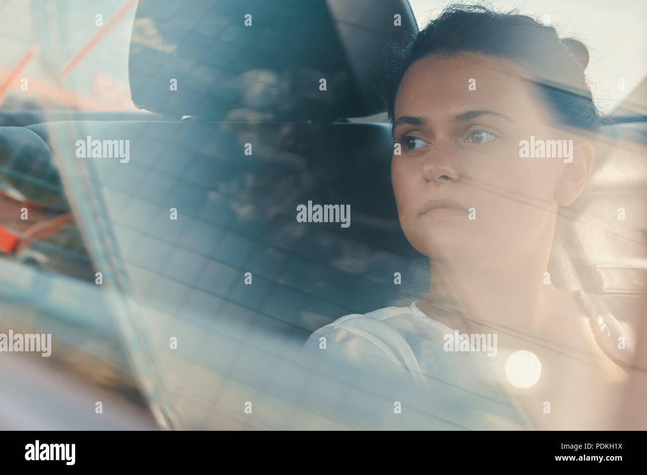 Die moderne Frau sitzt auf dem Rücksitz des Autos auf der Straße Reise entspannend Stockfoto