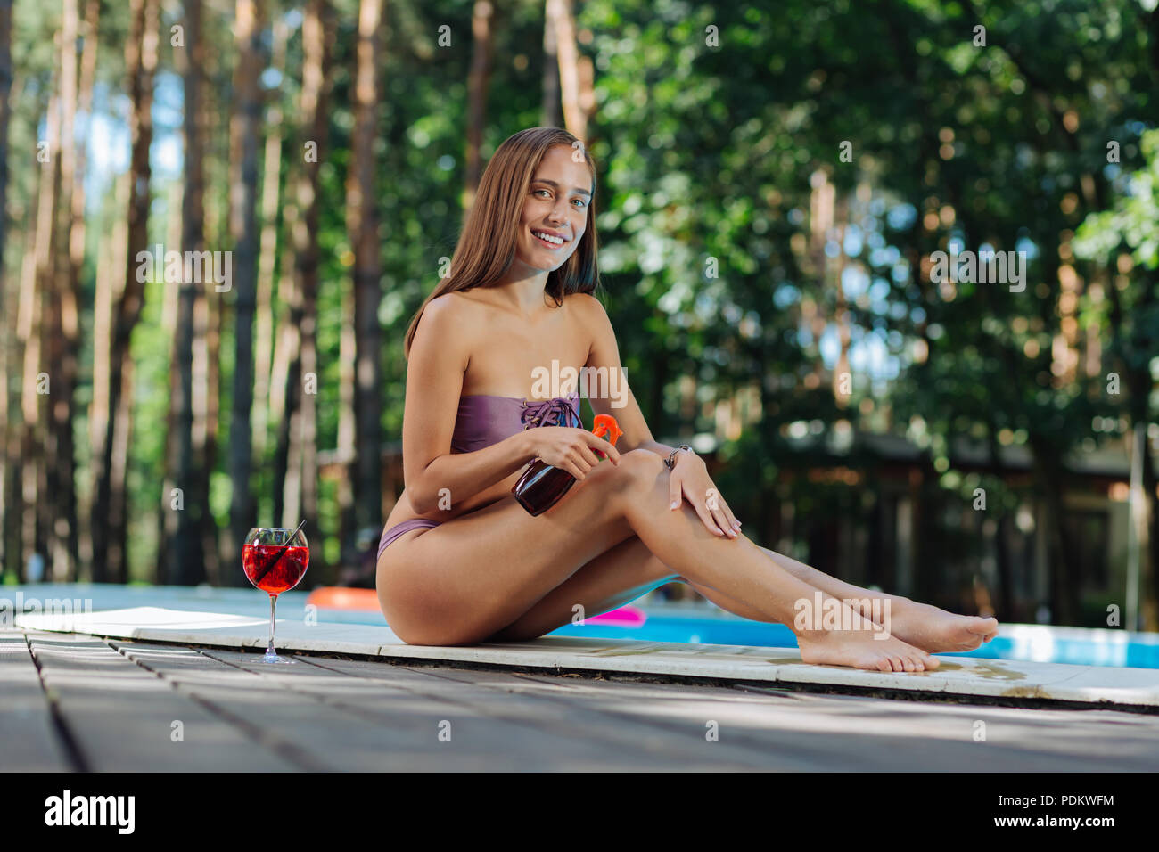 Schlanke Modell tragen Badesachen Sonnencreme erhalten in der Landschaft Stockfoto