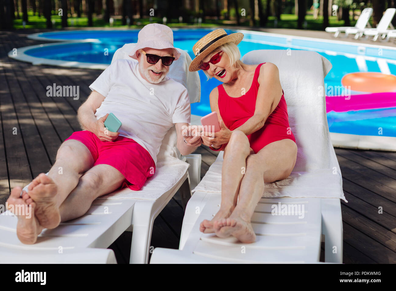 Großmutter und Großvater liegt auf Liegestühlen sonnenbaden Stockfoto