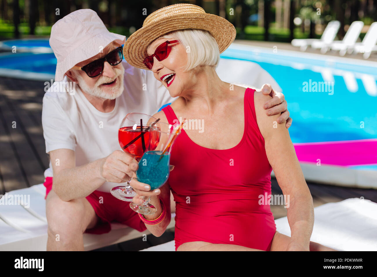 Blonde pensionierte Frau hören Witze von ihrem Mann Stockfoto