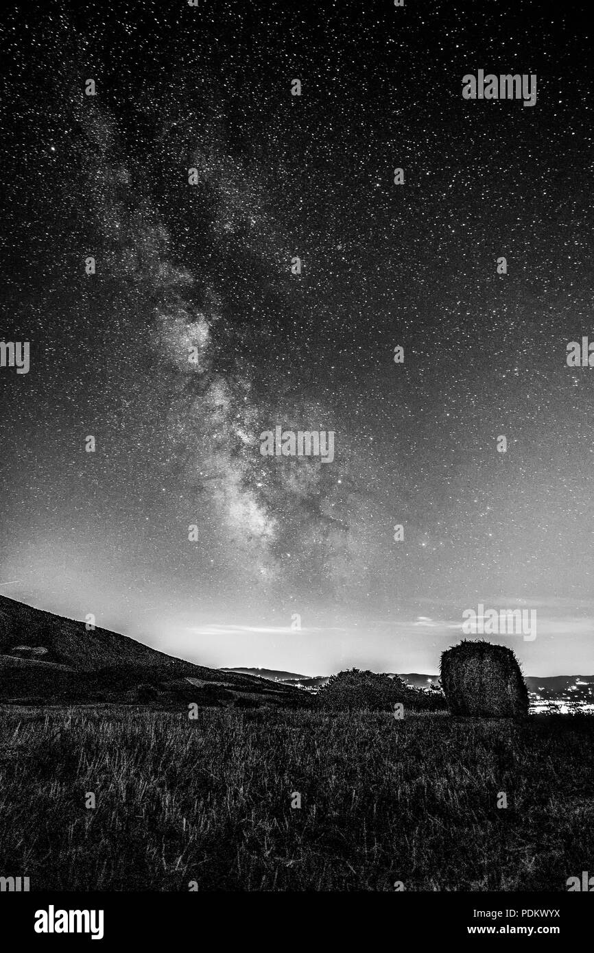 Wunderschöne Aussicht auf starred Nachthimmel mit Milchstraße über ein bebautes Feld mit Heu Ballen Stockfoto