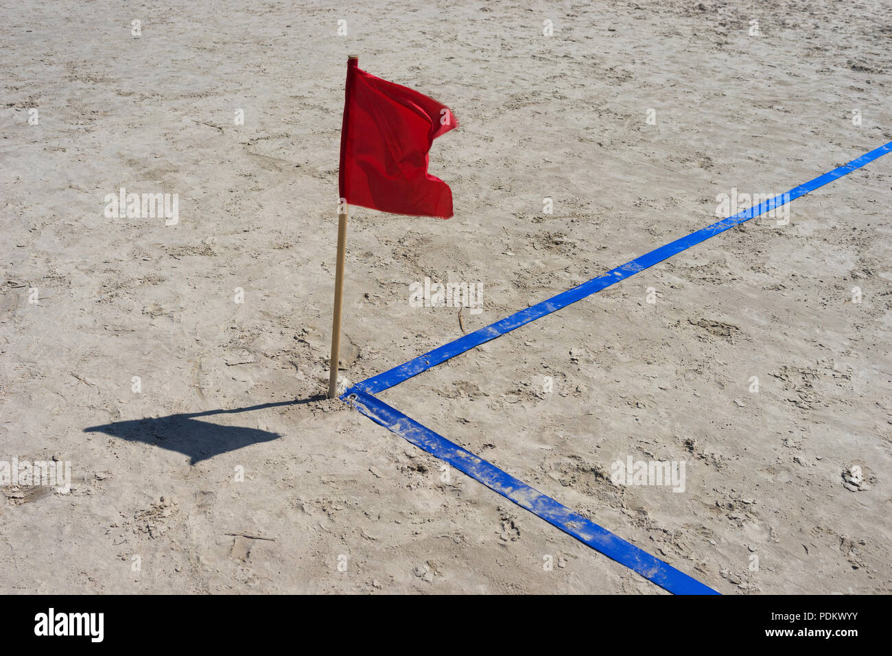 Winkel Spielplatz mit einem blauen Band und eine rote Flagge auf Sand. Ostsee Stockfoto