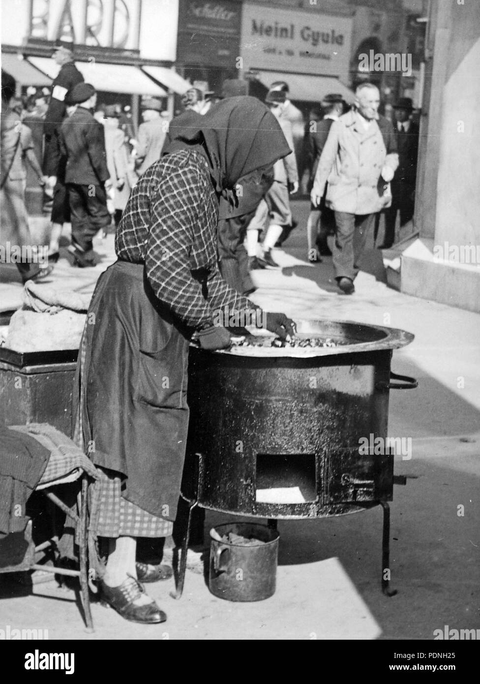 3 Budapest VIII. utcai gesztenyeárus, háttérben ein Rákóczi út 50. - Fortepan 14380 Stockfoto