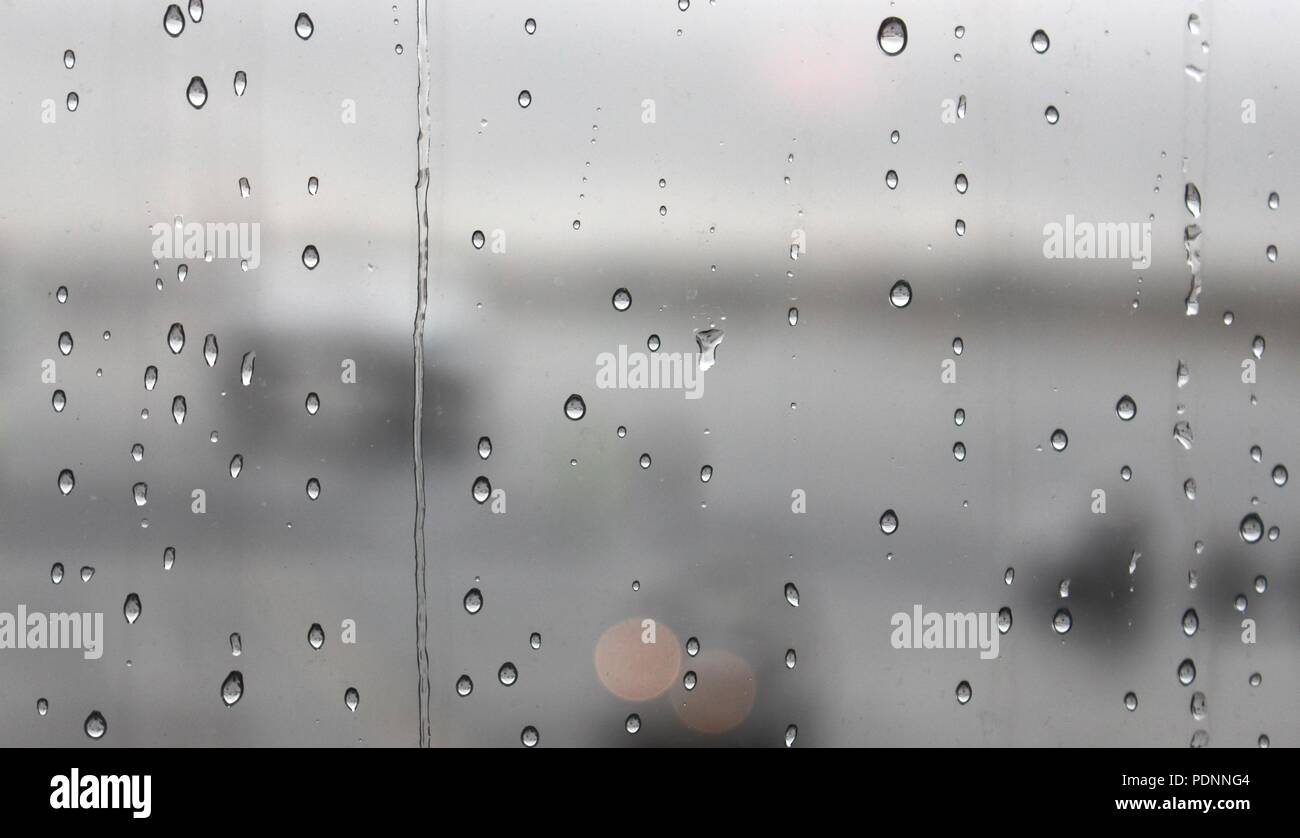 Regen fällt auf ein Fenster Stockfoto