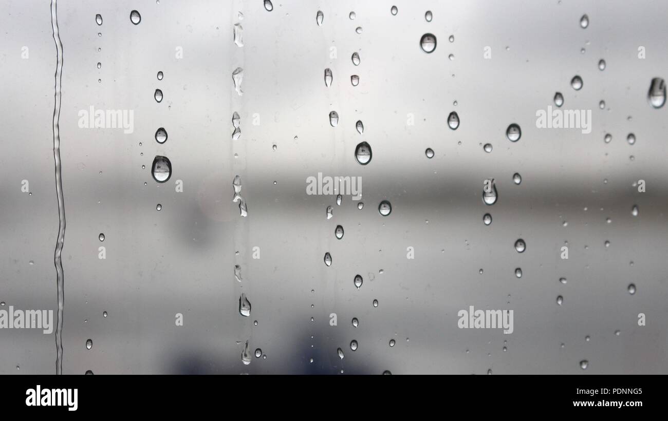 Regen fällt auf ein Fenster Stockfoto