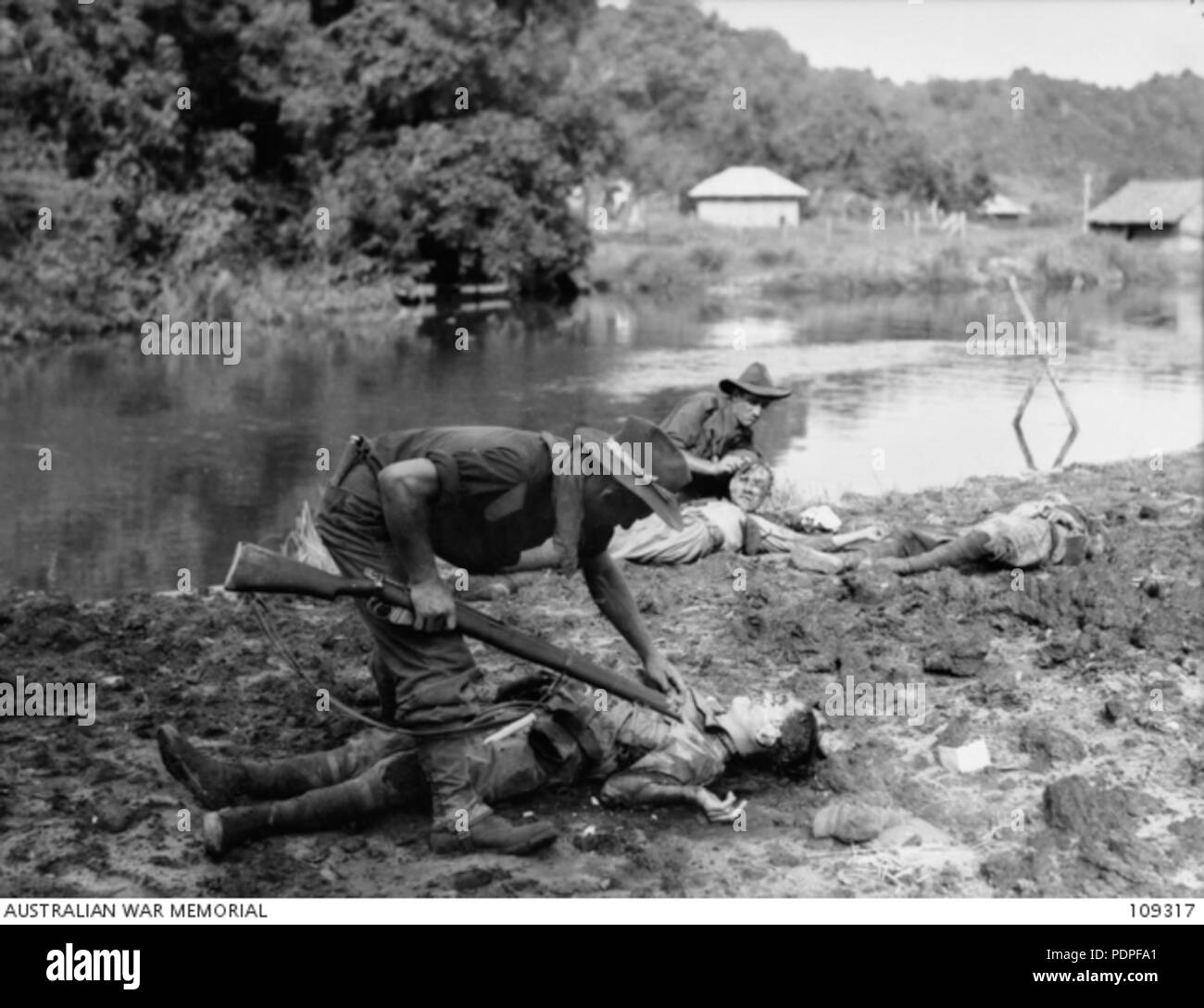 18 australische Truppen inspizieren die Körper der Toten japanischen Soldaten Stockfoto