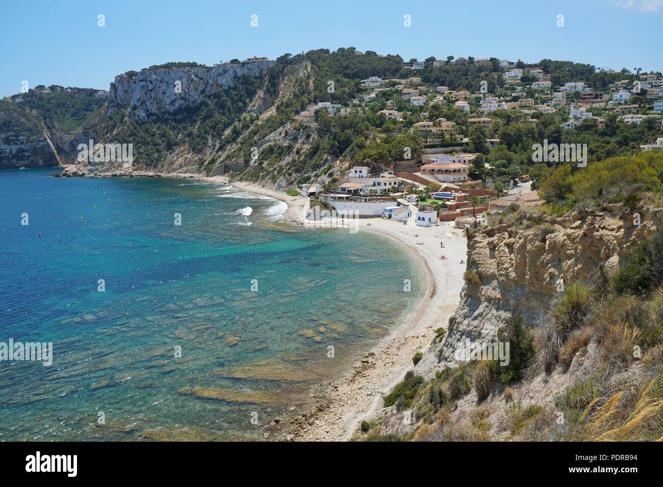 Strand und felsigen Küste mit Gebäuden in Javea, Cala Portitxol, Mittelmeer, Costa Blanca, Alicante, Valencia, Spanien Stockfoto