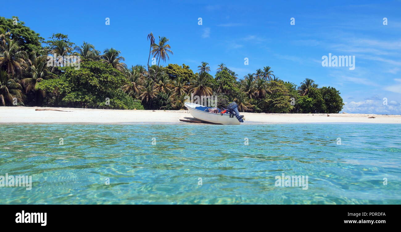 Unberührte Insel Meer mit tropischer Vegetation und einem Boot am Strand angelandet, Karibik, Panama Stockfoto