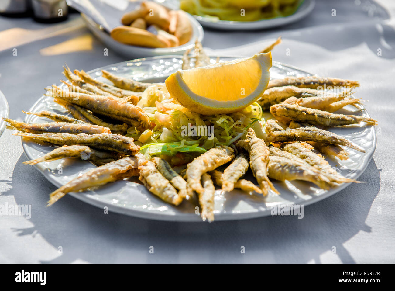 Platte von Frittierte Sardellen mit Zitrone und Salat Stockfoto