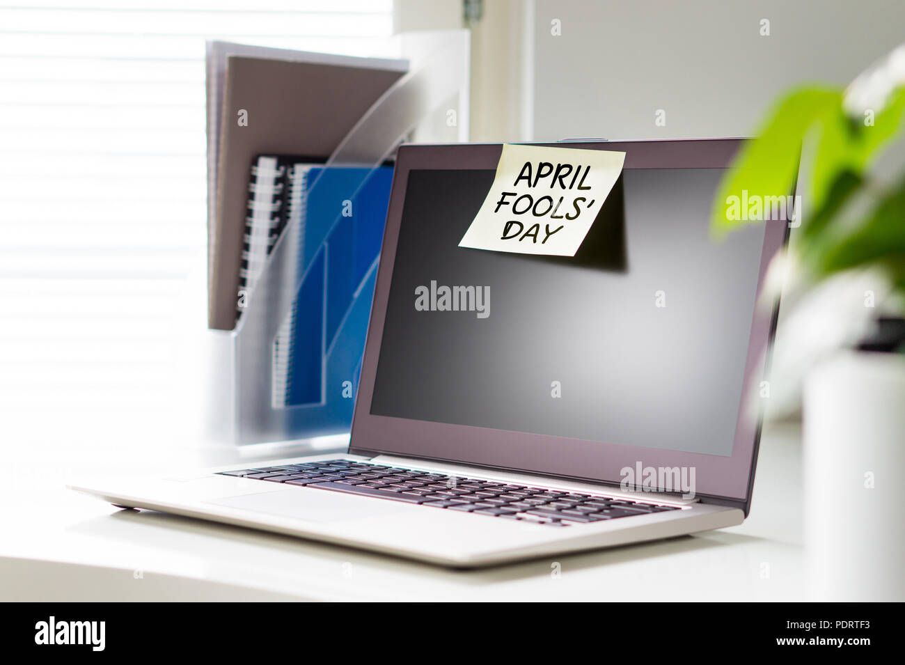 April Fools' Day Hinweis auf Laptop bei der Arbeit. Gelbe Haftnotiz auf Computer im Büro. Stockfoto