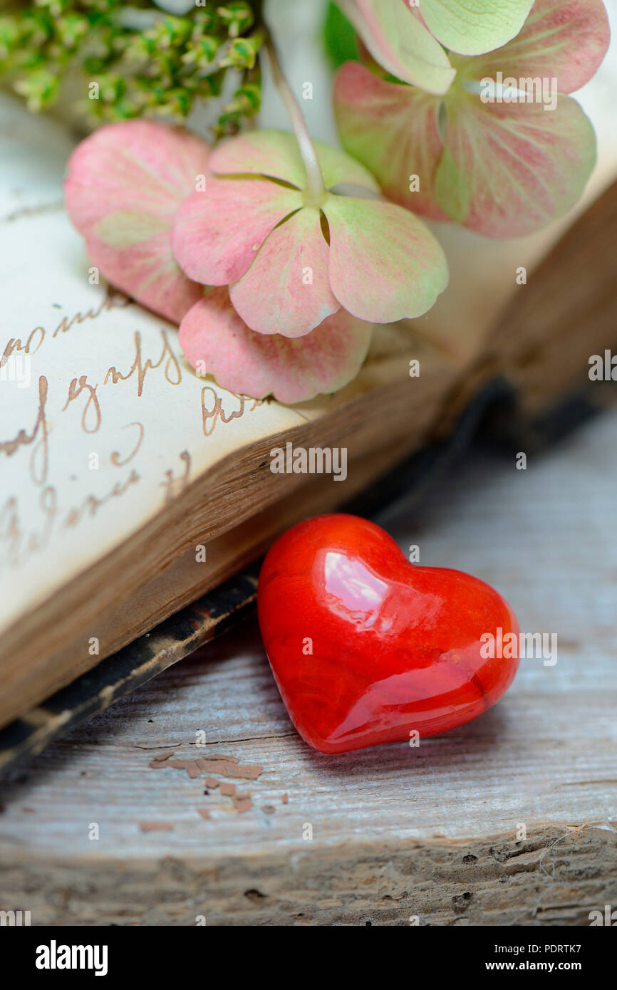 Rotes Herz in Buch mit alter Schrift Stockfoto