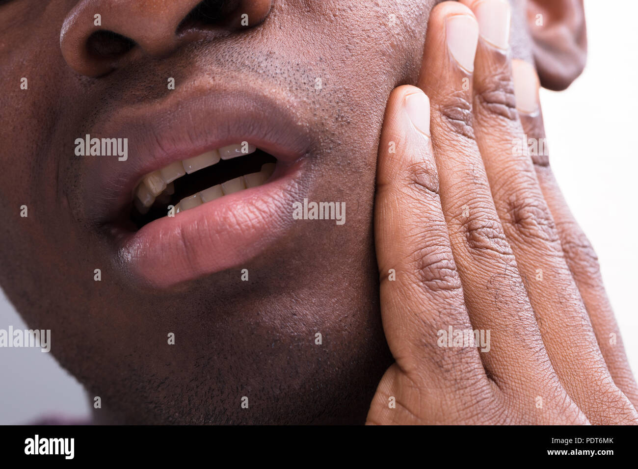 Nahaufnahme eines Mannes mit Zahnschmerzen vor weißem Hintergrund Stockfoto