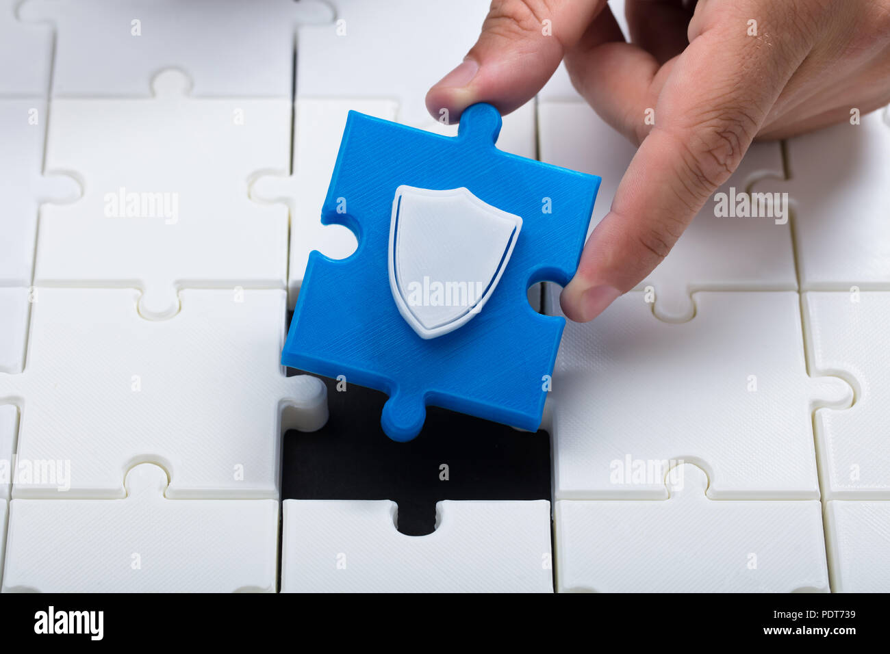 Eine Person anschließen letzte blaue Stück mit Schild in Jigsaw Puzzles Stockfoto
