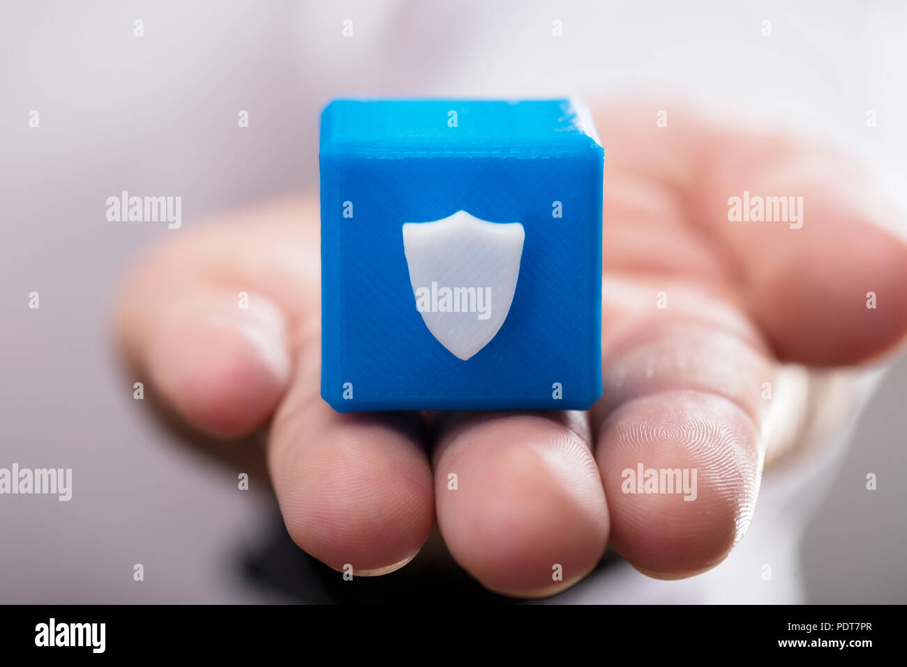 Nahaufnahme einer Hand Holding blau cubic Block mit Schild Symbol Stockfoto Nahaufnahme einer Hand Holding blau cubic Block mit Schild Symbol Stockfoto
