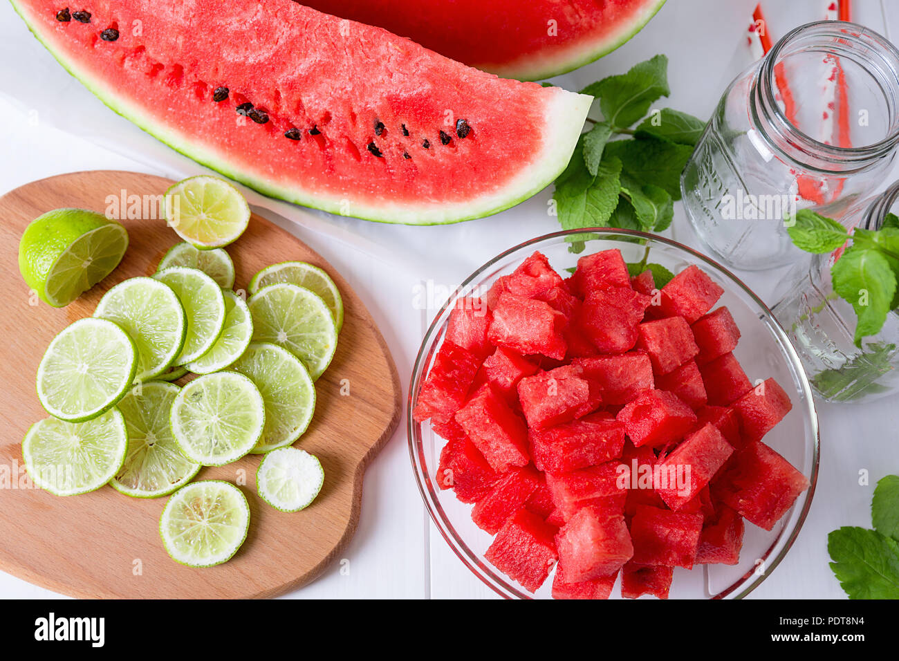 Zutaten zum Kochen Wasser hineingegossen. Scheiben Wassermelone und Kalk für detox Wasser Stockfoto