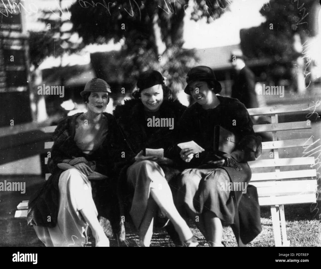 202 StateLibQld 1 105484 Trio der Damen, die das Studium der Form Rennen in Ascot, Brisbane, 1933 Stockfoto