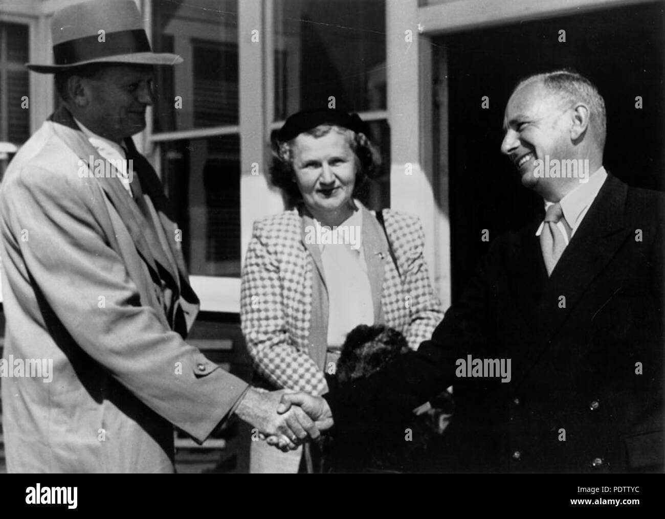 207 StateLibQld 1 113104 Offizielle Begrüßung durch den Staat Bibliothekar an der Eagle Farm Airport, 1954 Stockfoto