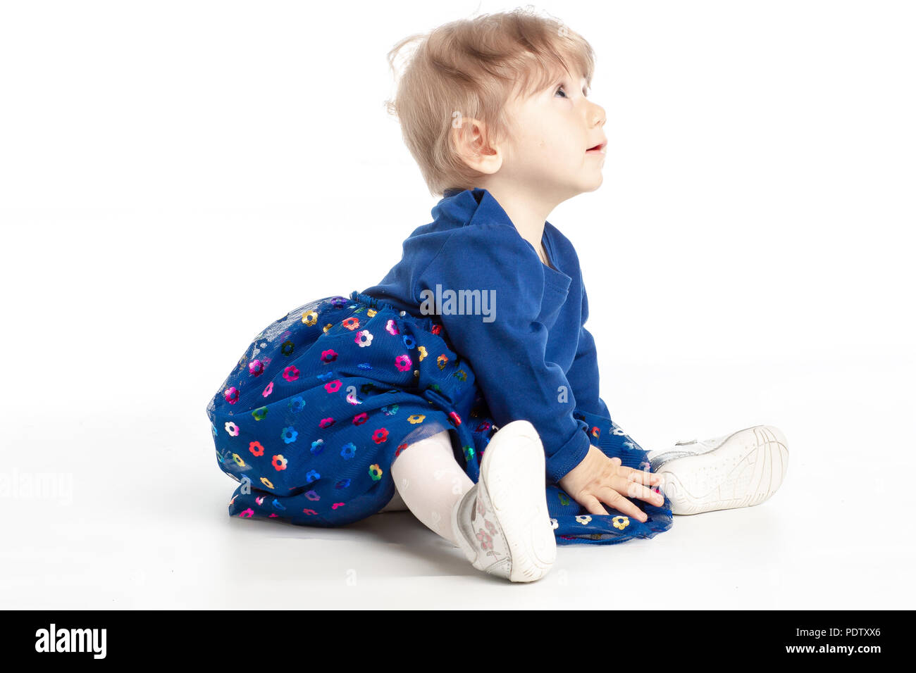 Elegante baby girl 1 Jahr alt sitzen auf dem Studio. Weißer Hintergrund. Stockfoto