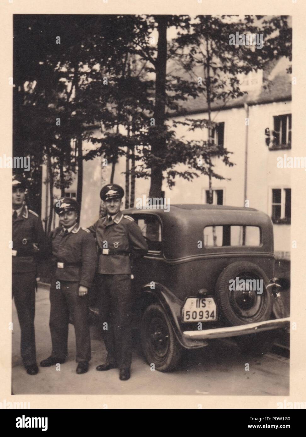 Bild aus dem Fotoalbum von Oberfeldwebel Karl gendner von 1. Staffel, Kampfgeschwader 40: Karl Gendner (Mitte) steht mit seinem Auto mit zwei Kollegen, außerhalb der Kaserne in Giebelstadt 1938 Stockfoto