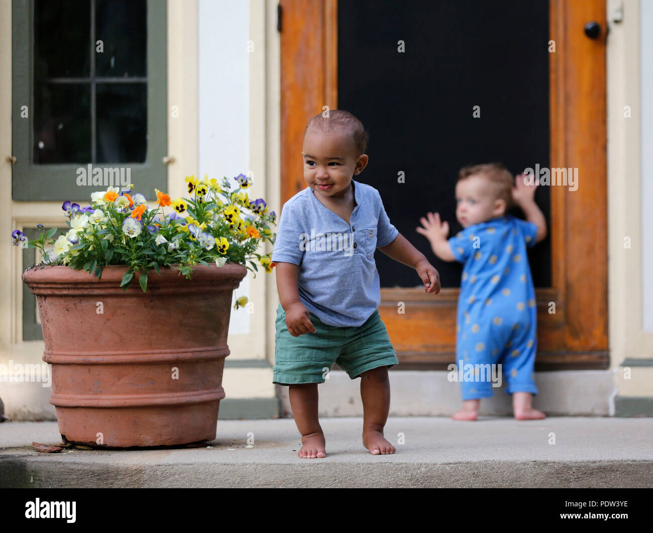 Zwei toddler Jungs das Innere eines Home untersuchen, indem man durch das Sieb. Stockfoto